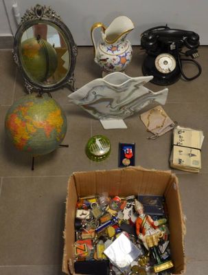 une boîte contenant divers objets, posée par terre à côté d'un miroir