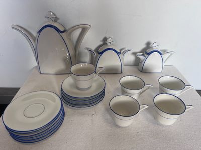 beaucoup d'assiettes et de tasses blanches et bleues sur la table