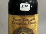 Des bouteilles de vin sont alignées sur une table devant un fond blanc.