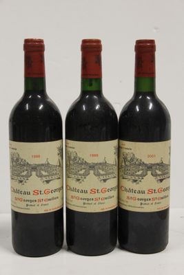 trois bouteilles de vin rouge posées sur une table blanche