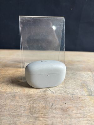 an apple airpods are sitting on a wooden table with a clear box