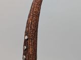 a close up of a pipe with a wooden handle on a table