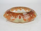 an orange and white bowl sitting on a white surface