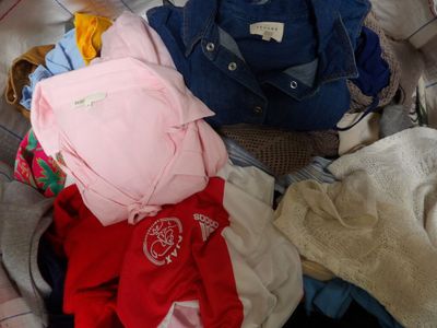 a pile of clothes sitting on top of a bed