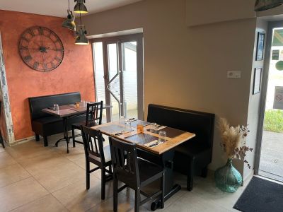 a dining room with a table and chairs and a clock on the wall