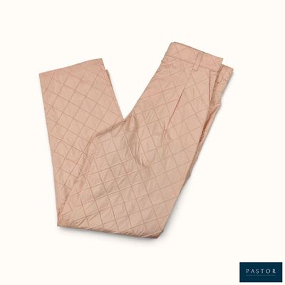 un pantalon matelassé rose sur fond blanc, avec une étiquette bleue