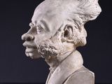 statue of a man with a mohawk and a beard on a black surface