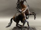 bronze statue of a man on a horse with a spear in his hand