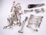 a lot of silverware and a pen on a table