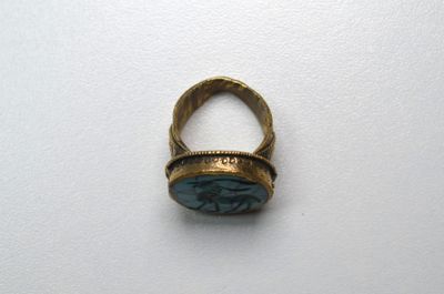 une image représentant une bague sertie d'une pierre, posée sur une surface blanche