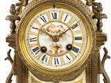 a gold clock with an ornate design on the face