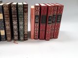 several books are lined up in a row on a white surface