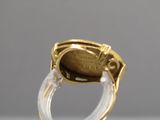 une image représentant une bague en or et transparente, avec une pièce à l'intérieur