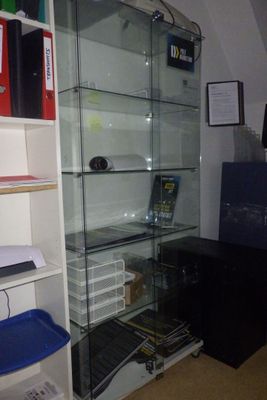 une vitrine en verre dans le coin d'une pièce