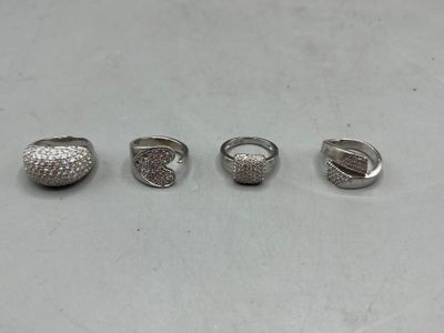 three rings with diamonds on them sitting on a white surface