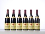 six bottles of red wine lined up in a row