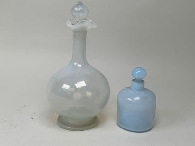 deux bouteilles en verre posées l'une à côté de l'autre sur une table