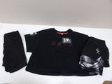 un t-shirt et un pantalon noirs, ainsi qu'un sweat à capuche et une casquette, posés sur une table