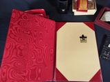 a red folder with a notepad and a pen on it