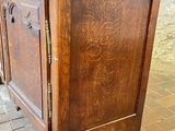 a small wooden cabinet on wheels on a brick floor