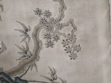 a close up of a piece of fabric with birds and flowers on it