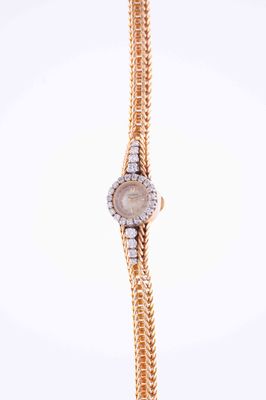 a close up of a wrist watch with a chain around it