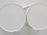 two white toilet seats sitting next to each other on a wall