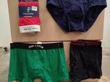 three men ' s underwear are displayed on a pallet in a room