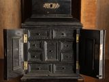un vieux poêle noir dont la porte est ouverte, posé sur une table en bois