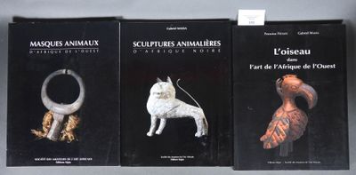 trois livres sur une étagère sur laquelle se trouvent un chien et un chat