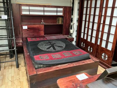 un lit recouvert d'une couverture noire, dans une chambre