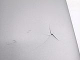 a crack in the back of a laptop that is sitting on a table