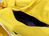 a yellow bag that is open on a white surface