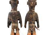 pair of wooden figurines of a man and a woman on a white background