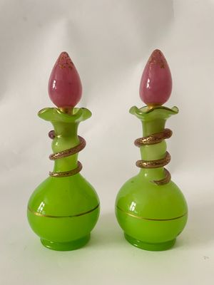 deux vases verts ornés de fleurs roses sur fond blanc