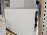 une photo d'un réfrigérateur dans un magasin, avec de nombreux articles éparpillés sur le sol
