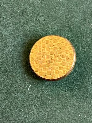 une petite pièce d'or posée sur une surface verte