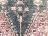an antique rug with a pink and blue design on a white background