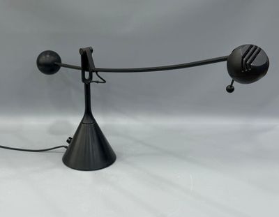 un gros plan d'une lampe posée sur une surface blanche, avec un fond gris