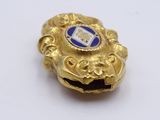a gold ring with a blue and white emblem on it