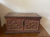 an old wooden chest sitting on top of a table next to a lamp
