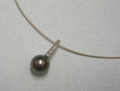 collier en métal argenté orné d'une perle noire et d'un pendentif en diamant