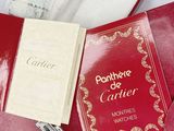 a red book with a silver watch and a red book with a silver watch