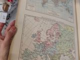 a person holding an open book with a map on it