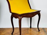 a person standing next to a chair with a yellow seat