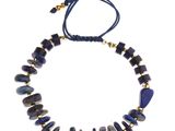 un collier composé de perles bleues et dorées sur fond blanc