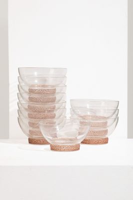 une pile de bols en verre posée sur une étagère blanche