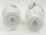 two salt and pepper shakers sitting on a white surface
