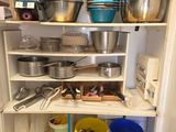 de nombreuses casseroles et poêles sur les étagères de la cuisine