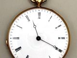 une montre de poche en or avec des chiffres romains sur le cadran
